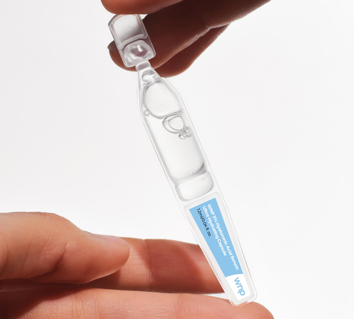 Clear plastic tube with blue label held between fingers on a white background